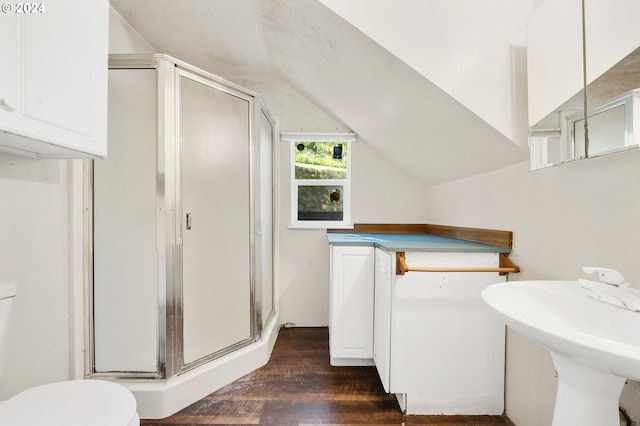 bathroom with lofted ceiling, toilet, a shower with shower door, sink, and wood-type flooring