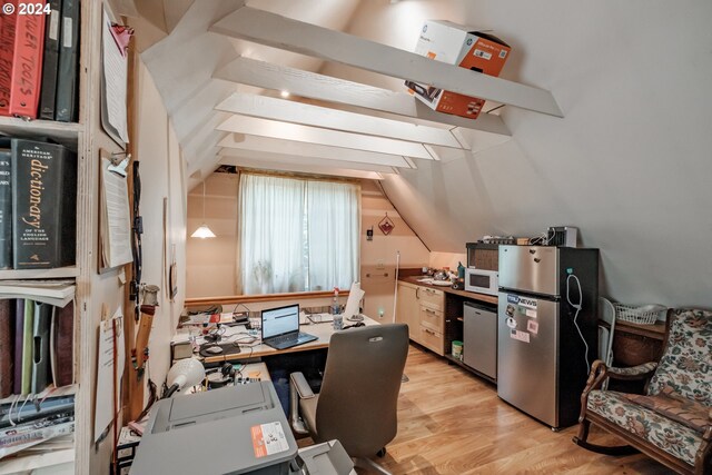 office featuring lofted ceiling and light hardwood / wood-style floors