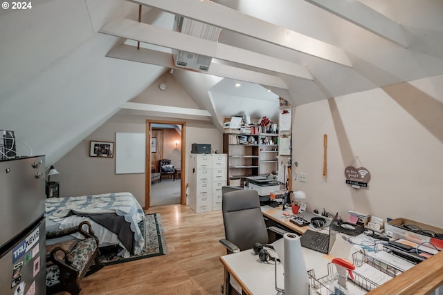 bedroom featuring light wood-type flooring, lofted ceiling, and stainless steel refrigerator