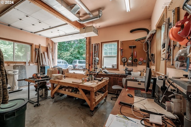 miscellaneous room with concrete flooring, a workshop area, and plenty of natural light