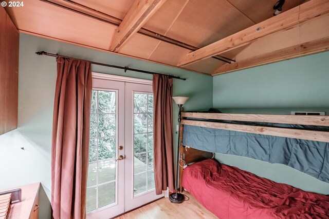 bedroom with beam ceiling, access to outside, french doors, and wood-type flooring