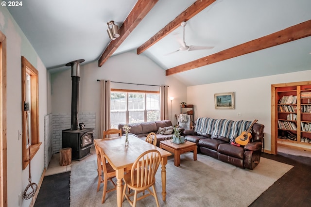 living room with ceiling fan, light wood-type flooring, vaulted ceiling with beams, and a wood stove