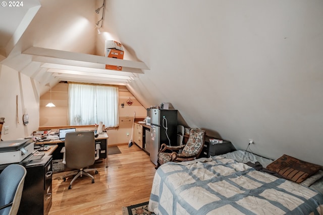 bedroom with track lighting, vaulted ceiling, and light hardwood / wood-style flooring