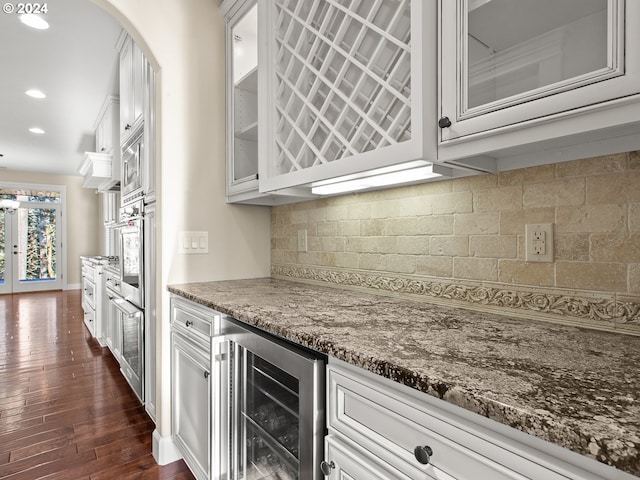 bar with a dry bar, recessed lighting, decorative backsplash, dark wood-type flooring, and beverage cooler