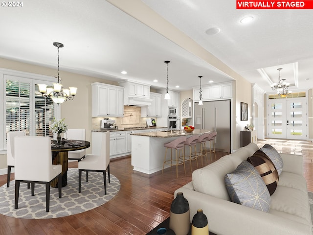 interior space with a wealth of natural light, dark wood-style flooring, and an inviting chandelier