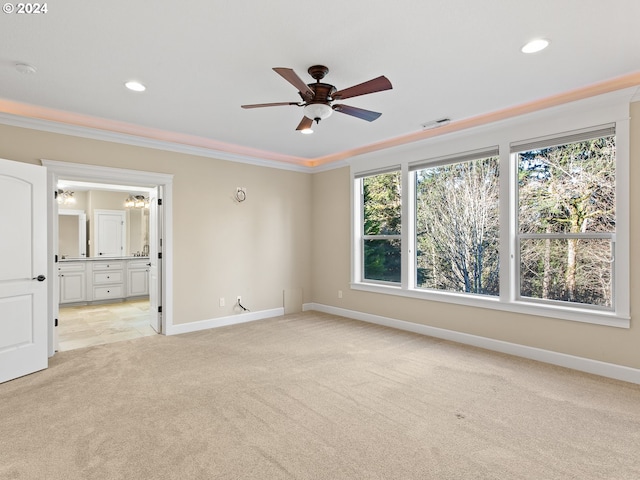 unfurnished bedroom featuring light colored carpet, crown molding, baseboards, and multiple windows