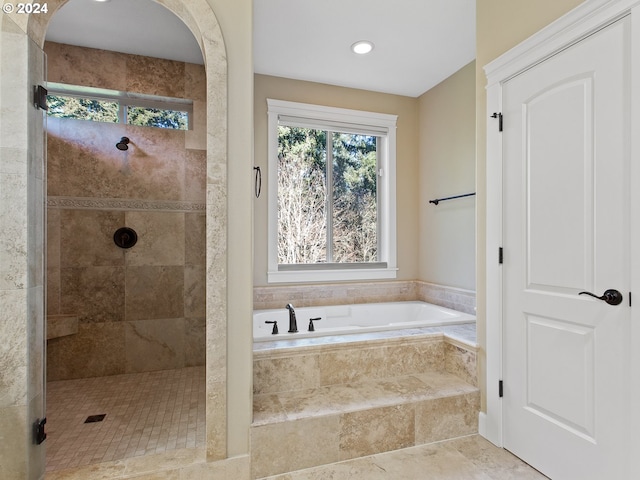 bathroom featuring a stall shower and a bath