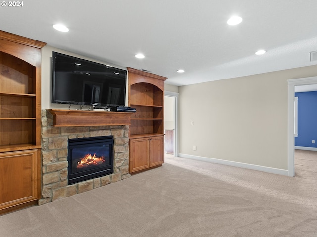 unfurnished living room featuring baseboards, a stone fireplace, recessed lighting, and light colored carpet