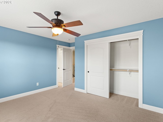 unfurnished bedroom featuring light carpet, a ceiling fan, baseboards, and a closet