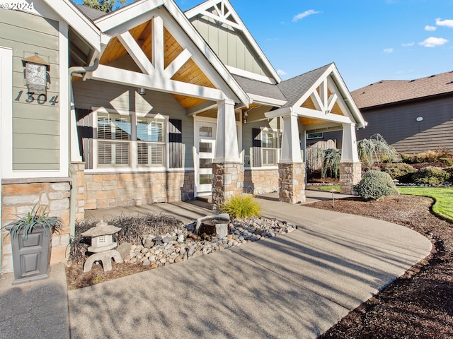 view of front of house with stone siding, covered porch, and board and batten siding