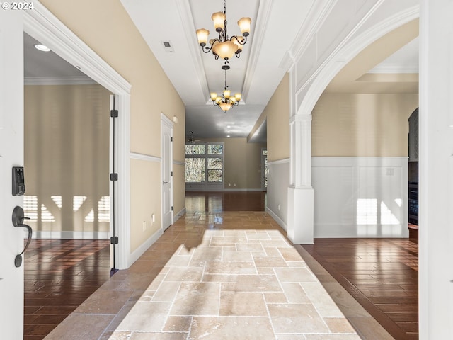 entrance foyer with arched walkways, visible vents, an inviting chandelier, ornamental molding, and ornate columns