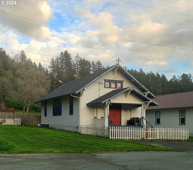 bungalow with a front lawn and a fenced front yard