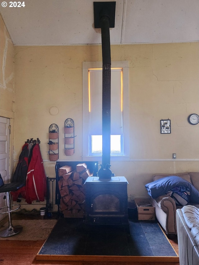 interior space with a wood stove and wood finished floors