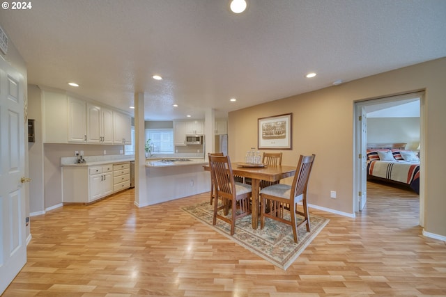 dining room featuring a textured ceiling and light wood-type flooring