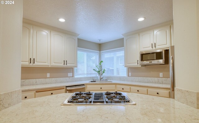 300 Spinnaker Way, Columbia City, OR 97018 - kitchen with appliances with stainless steel finishes, a textured ceiling, light stone counters, a sink, and recessed lighting