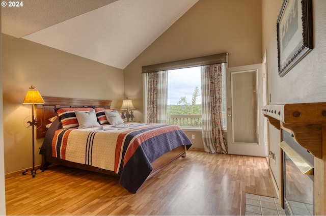 bedroom featuring light hardwood / wood-style floors and high vaulted ceiling