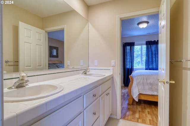 bathroom featuring vanity, wood-type flooring, and a textured ceiling