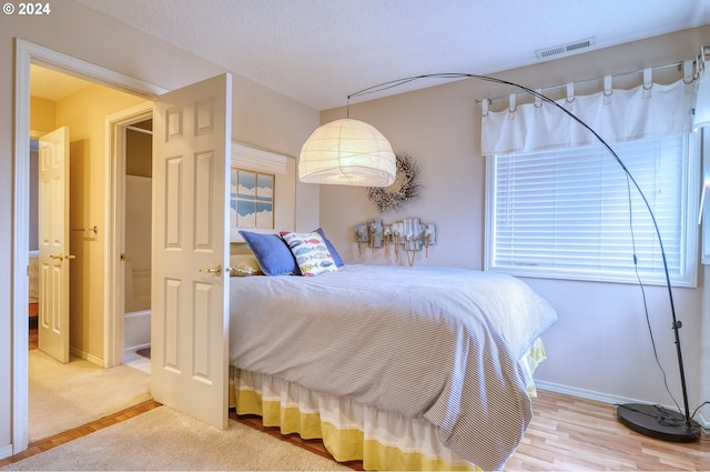 bedroom featuring wood-type flooring and a textured ceiling