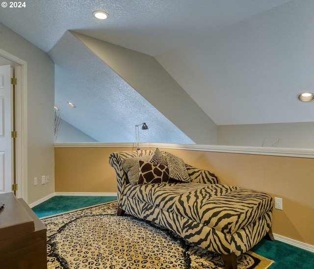 carpeted bedroom with a textured ceiling and lofted ceiling