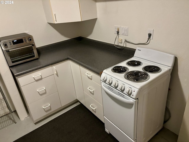 kitchen with white electric range oven and white cabinetry