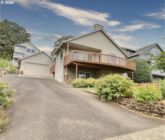 300 Spinnaker Way, Columbia City, OR 97018 - view of front facade featuring a detached garage, a chimney, and a wooden deck
