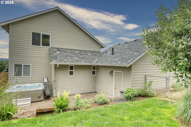 rear view of property with a hot tub