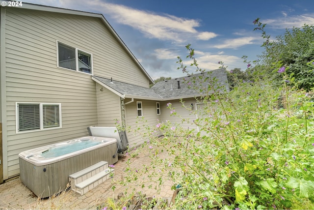 rear view of property with a hot tub