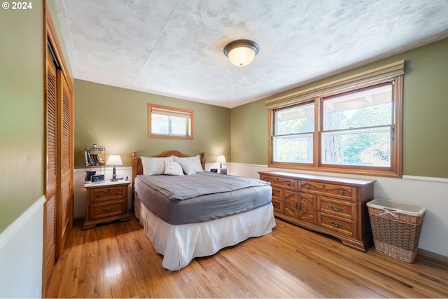 8805 NE 36th St, Vancouver, WA 98662 - bedroom featuring light wood finished floors, a textured ceiling, a closet, and a wainscoted wall