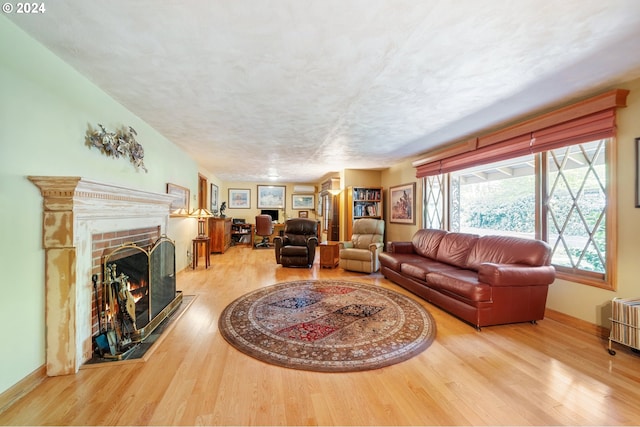 8805 NE 36th St, Vancouver, WA 98662 - living room with a textured ceiling, baseboards, wood finished floors, and a brick fireplace