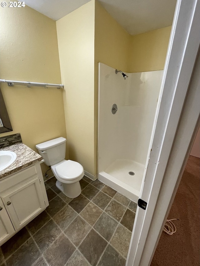 bathroom featuring walk in shower, tile patterned flooring, vanity, and toilet