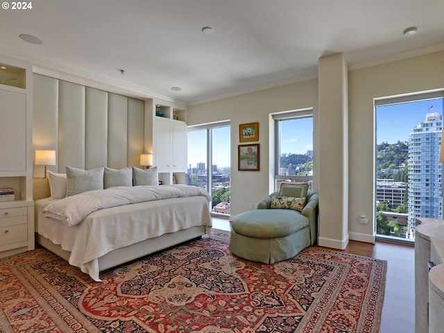 bedroom with crown molding, access to exterior, and hardwood / wood-style floors