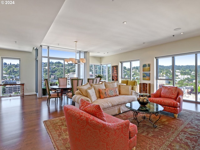 living area with baseboards, dark wood-type flooring, recessed lighting, and an inviting chandelier