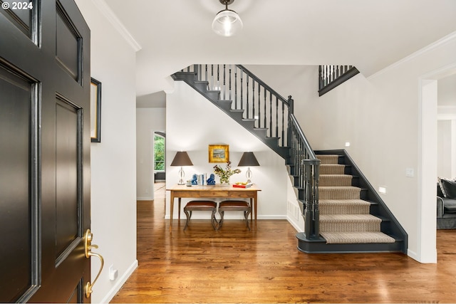 entrance foyer with ornamental molding and hardwood / wood-style flooring