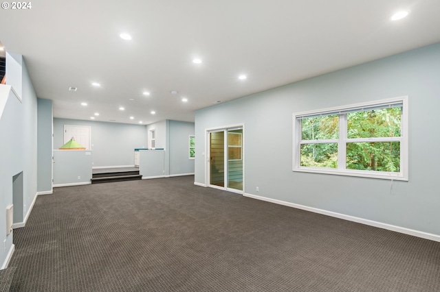 unfurnished living room featuring dark colored carpet