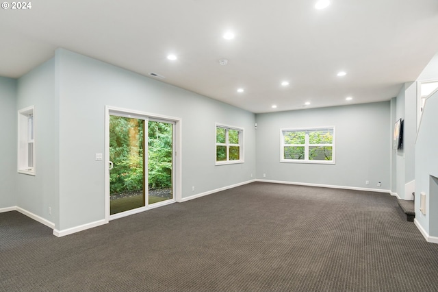 spare room featuring dark colored carpet