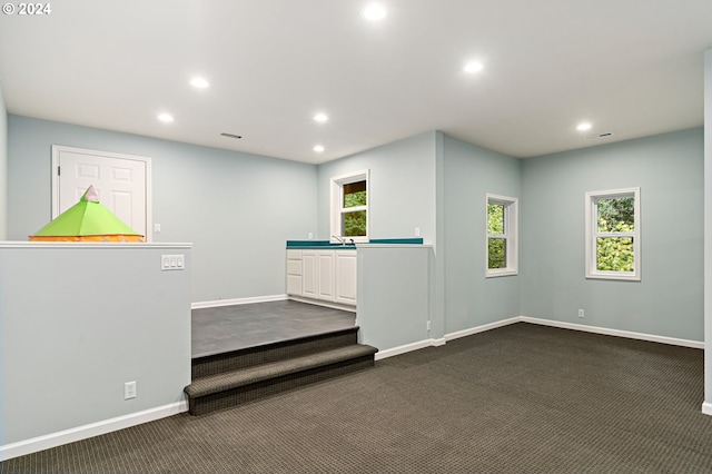 unfurnished room featuring dark colored carpet