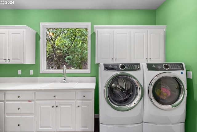 clothes washing area with independent washer and dryer, sink, and cabinets