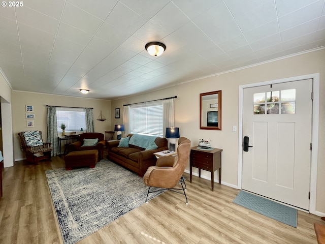 living area featuring light wood finished floors, baseboards, and ornamental molding