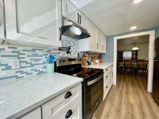 kitchen with tasteful backsplash, white cabinets, stainless steel range with electric cooktop, light wood-type flooring, and under cabinet range hood