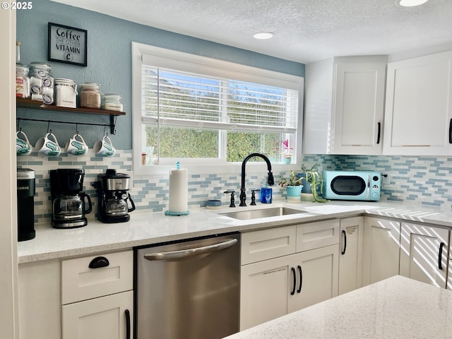 665 Clearlake Ave, Winchester Bay, OR 97467 - kitchen with dishwasher, a sink, white cabinetry, and a textured ceiling