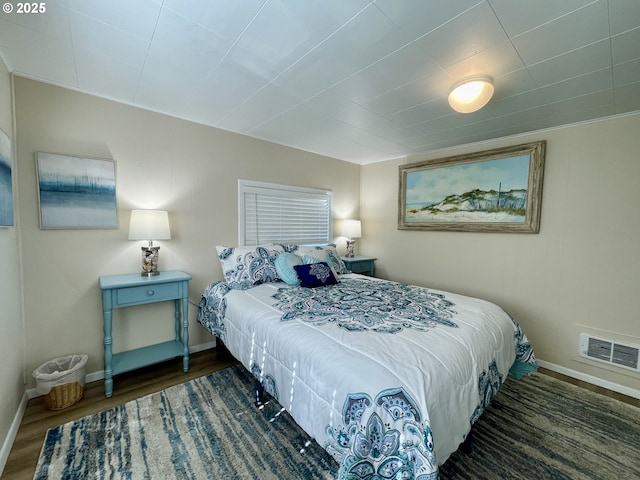 bedroom with baseboards and wood finished floors