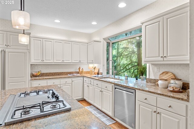 1739 Palisades Terrace Dr, Lake Oswego, OR 97034 - kitchen with stainless steel appliances, a sink, white cabinetry, pendant lighting, and recessed lighting