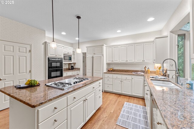 1739 Palisades Terrace Dr, Lake Oswego, OR 97034 - kitchen featuring a sink, stainless steel appliances, light stone counters, a kitchen island, and white cabinets