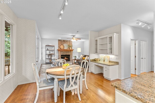 1739 Palisades Terrace Dr, Lake Oswego, OR 97034 - dining area with rail lighting, light wood-type flooring, a fireplace, a ceiling fan, and plenty of natural light