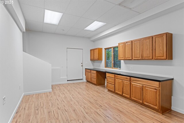 1739 Palisades Terrace Dr, Lake Oswego, OR 97034 - kitchen featuring brown cabinetry, a paneled ceiling, light wood finished floors, baseboards, and built in desk