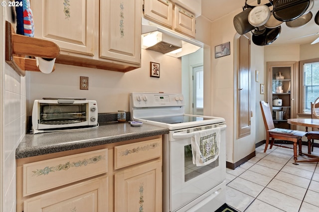 kitchen featuring white electric stove, light brown cabinets, and light tile patterned floors