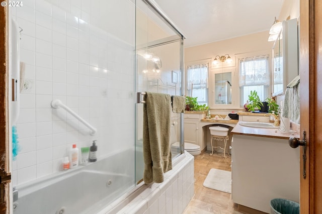 full bathroom with tile patterned floors, shower / bath combination with glass door, vanity, and toilet