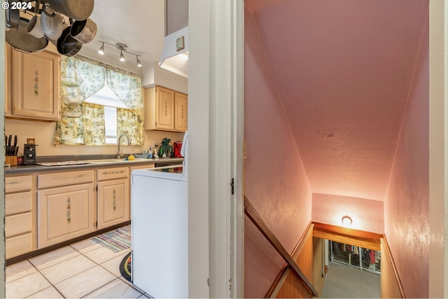 kitchen with washer / clothes dryer, sink, decorative light fixtures, light tile patterned floors, and light brown cabinetry