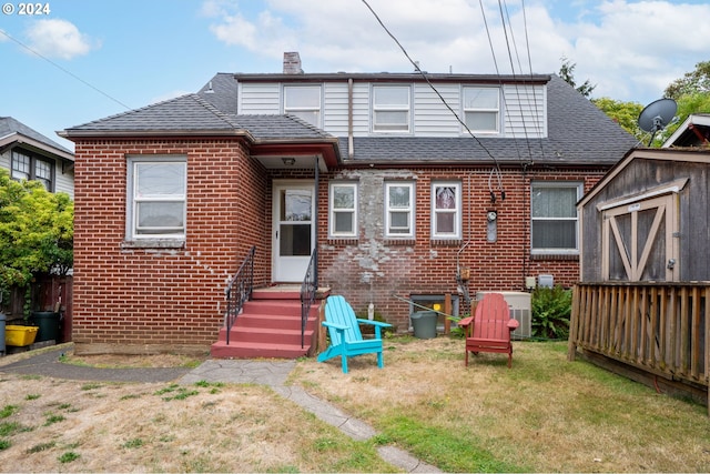 rear view of house featuring a lawn and central AC unit