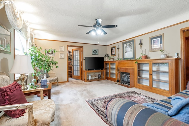 carpeted living room featuring ornamental molding, ceiling fan, a fireplace, and a textured ceiling